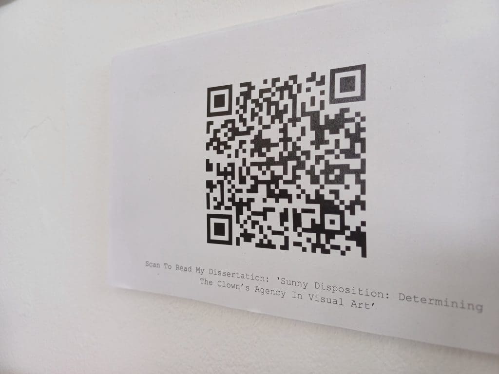 A QR code on a white surface, with the title of a student's dissertation underneath. 