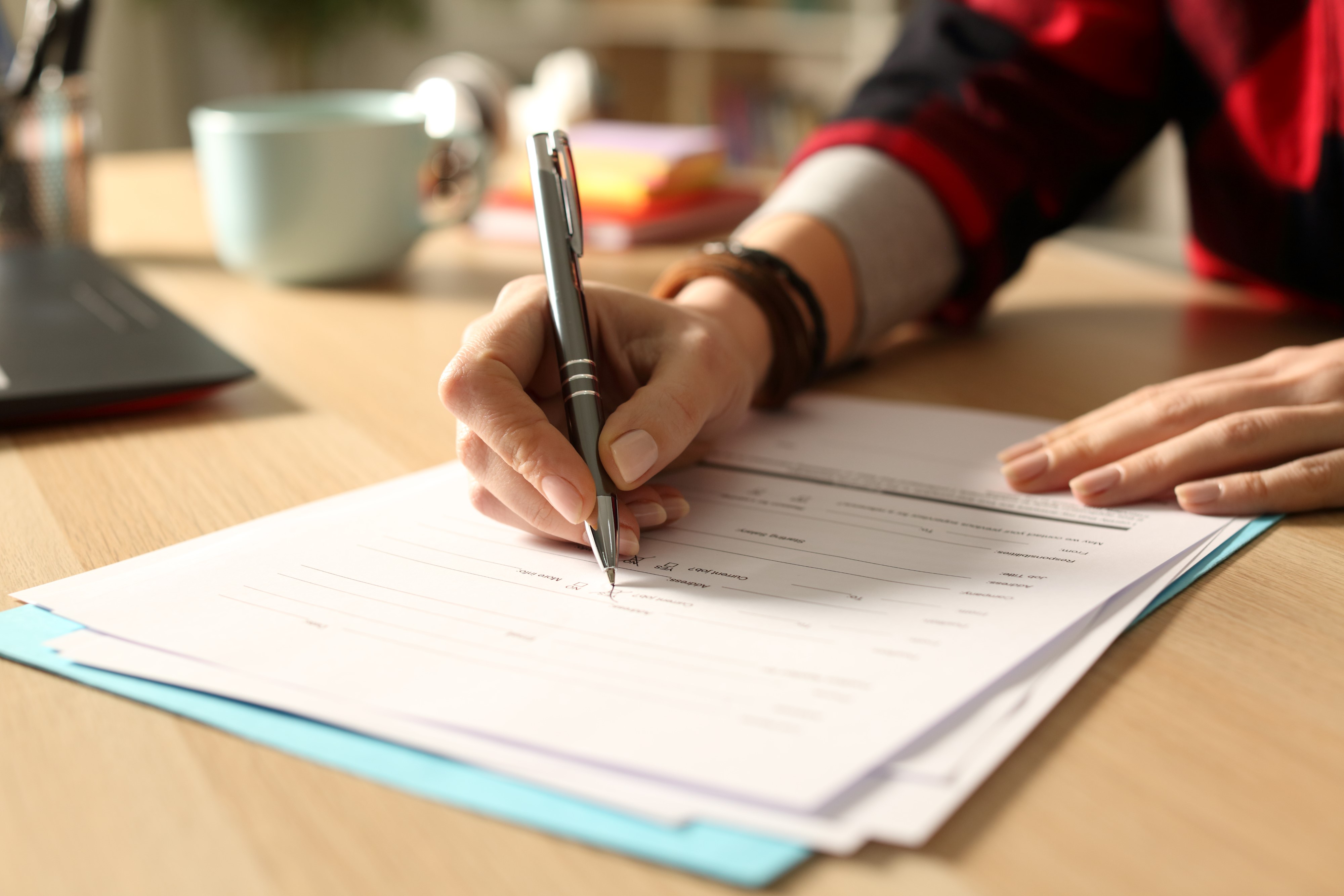 Hand filling in a form on paper